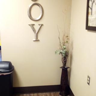 A corner of an office adorned with decorative letters, a plant, and a trash can.