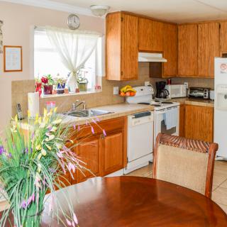A cozy kitchen and dining area featuring wooden cabinets, a table with chairs, and various appliances.