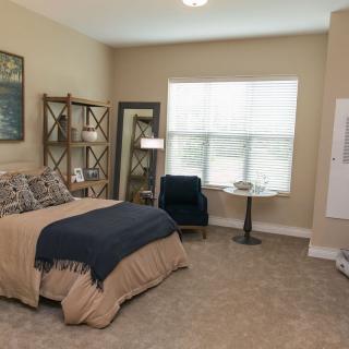 A cozy, well-decorated bedroom with neutral tones and stylish furnishings.