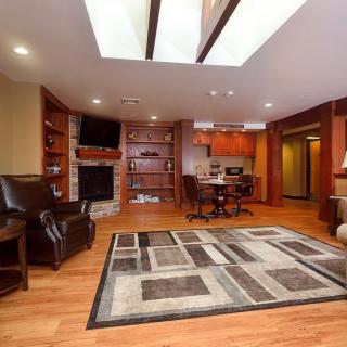 A modern living room with wood flooring, featuring a cozy fireplace and integrated shelving.
