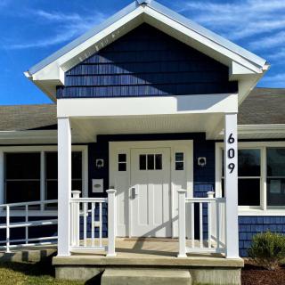 A charming blue house with a small porch and white accents.