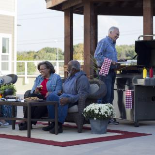 A group of people enjoying a barbecue on a patio.