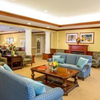 A cozy living room with comfortable sofas, a wooden coffee table, and decorative artwork above a fireplace.