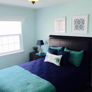 A modern bedroom with blue tones and decorative pillows.