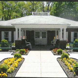 A charming residential building with a well-maintained entrance and colorful flower beds.