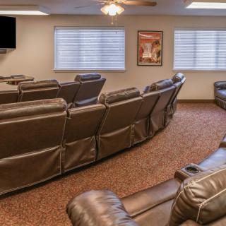 A cozy home theater with multiple recliners facing a large TV.