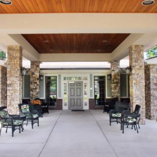 A building entrance with stone pillars and outdoor seating.