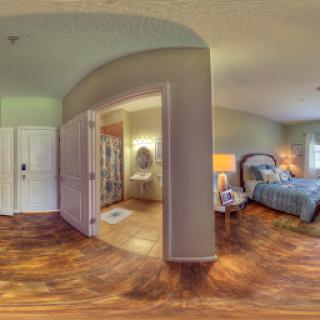 A cozy and inviting bedroom space with wooden flooring and soft lighting.