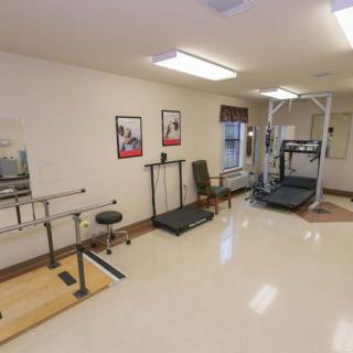 A rehabilitation room featuring various physical therapy equipment and exercise machines.