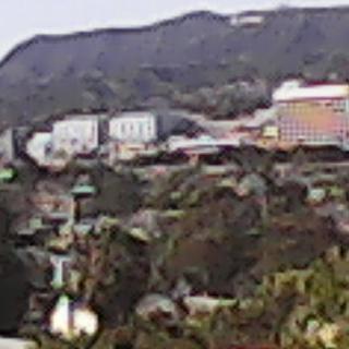 A view of a hilly landscape with buildings in the background.