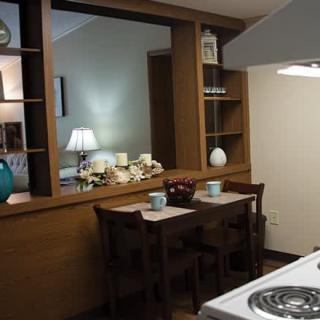A cozy kitchen with a small dining area featuring wooden furniture and decor.