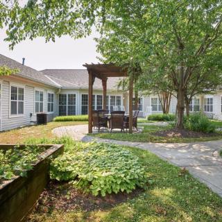 A peaceful courtyard with a gazebo and lush greenery.