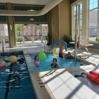 A fun afternoon at an indoor pool with friends enjoying leisure time and a variety of pool toys.
