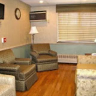 A cozy living room with comfortable chairs, a lamp, and a television.