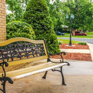 A beautifully designed bench surrounded by lush greenery, inviting for a moment of relaxation.