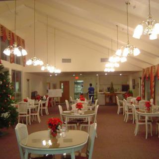 An elegantly decorated dining area with neatly arranged tables and chairs under soft lighting.