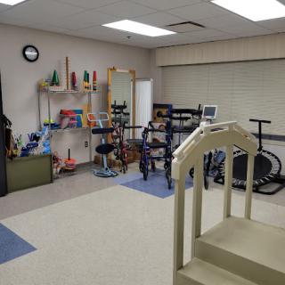 A well-equipped therapy room featuring various exercise and rehabilitation equipment.