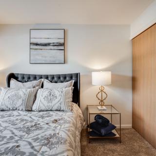 A cozy bedroom with a stylish bed, modern nightstand, and elegant decor.