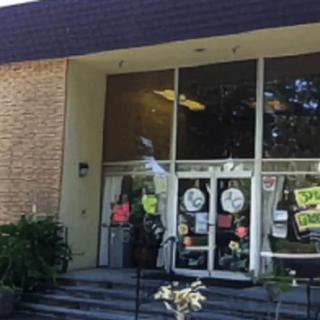 A storefront with glass doors, featuring various signs and advertisements.