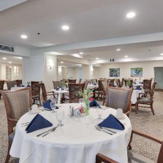 A spacious dining room with neatly arranged tables and elegant table settings.