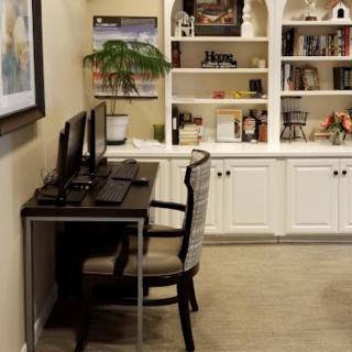 A cozy home office setup with a desk, computer, and bookshelf.