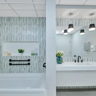 A contemporary bathroom featuring a stylish tub and modern vanity with elegant lighting.