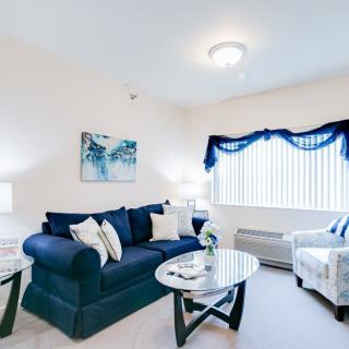 A bright living room with a blue sofa, modern furnishings, and decorative elements.