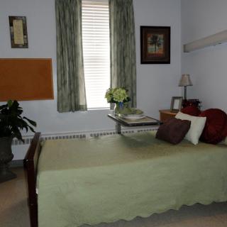 A cozy bedroom featuring a neatly made bed, soft lighting, and decorative elements.