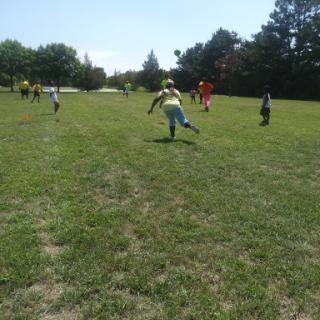 Children enjoying a game of soccer in a sunny park.