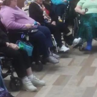A group of people sitting in wheelchairs indoors.
