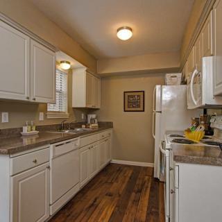 A cozy kitchen with white cabinets and wooden flooring.