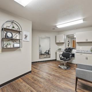 A clean and modern hair salon interior featuring a styling chair, mirror, and elegant decor.