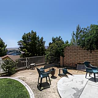 A sunny backyard with patio chairs and a scenic view.