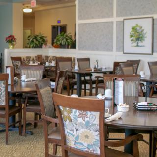 A well-decorated dining area with several empty tables and chairs.