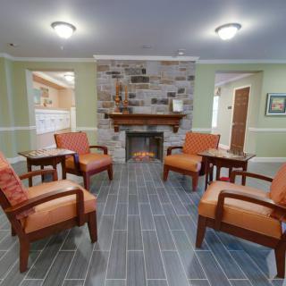 A cozy living room with a stone fireplace and comfortable seating arrangement.
