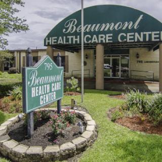 Exterior view of the Beaumont Health Care Center, showcasing its welcoming entrance and landscaped surroundings.