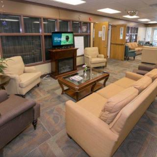 A cozy living room with sofas, chairs, and a television.