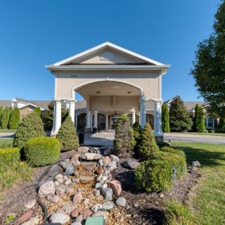 A well-maintained entrance to a building with manicured landscaping and a stone pathway.