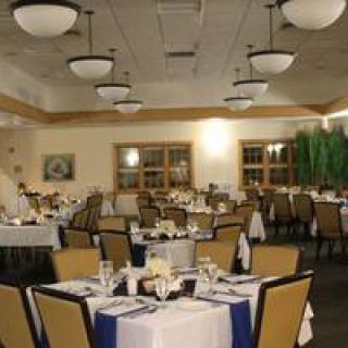An elegant restaurant dining room with neatly arranged tables and chairs, featuring stylish lighting.