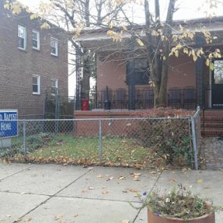 A cozy residential house with a fenced yard, showcasing autumn leaves.
