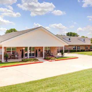 A residential building with a landscaped front yard and a clear sky.