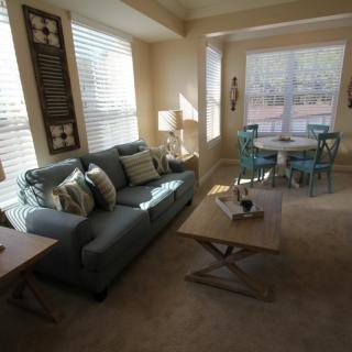 A cozy living room with a sofa, coffee table, and adjoining dining area.