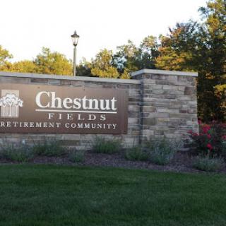 Entrance sign for Chestnut Fields Retirement Community, surrounded by well-maintained landscaping.