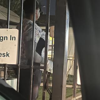 A person standing at a gated check-in desk.