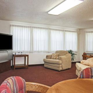 A cozy living room with comfortable seating, a large TV, and ample natural light streaming through the windows.
