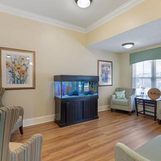 A cozy living room featuring an aquarium and elegant seating.