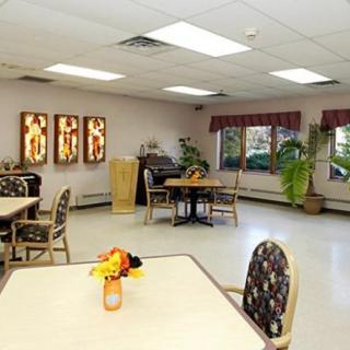 A well-lit dining area with tables, chairs, and decorative elements including plants and wall art.