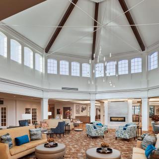 A spacious, well-lit lobby with modern seating and a large chandelier.