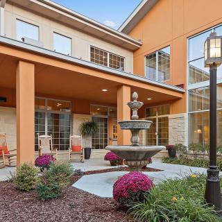 A well-maintained building with a fountain and landscaped garden area.