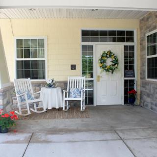 A welcoming front porch with rocking chairs and a wreath on the door.